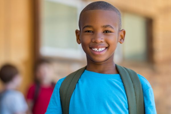 Boy at school with backpack.